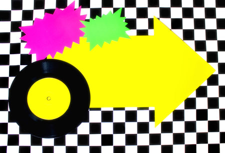 Photograph of 45rpm record with colorful shapes on Checkered floorの写真素材