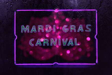 Neon Mardi Gras Party Sign in Rainy Wet Windowの写真素材