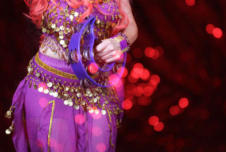 Belly Dancer wearing purple dance costume close up with colorful bokehの写真素材