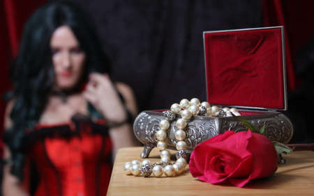 Vintage Jewelry Box with Pearls and rose, Woman in red corset in backgroundの写真素材