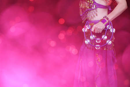 Belly Dancer wearing purple dance costume close up with colorful bokehの写真素材