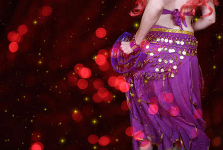 Belly Dancer wearing purple dance costume close up with colorful bokehの写真素材