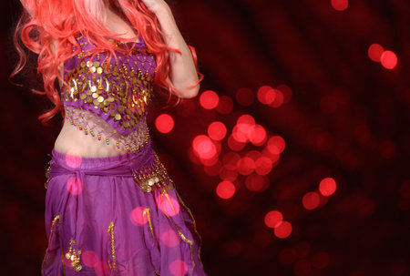 Belly Dancer wearing purple dance costume close up with colorful bokehの写真素材