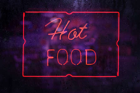 Vintage Style Neon Hot Food Sign in Rainy Windowの写真素材
