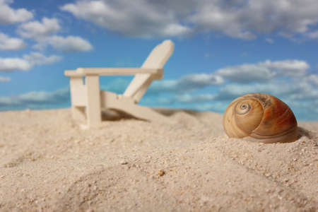 Sea Shell and Beach Chair on Sand, Shallow DOF, Focus on Shellの写真素材