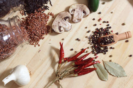 Jars of Red and Wild Rice on Rustic Table With Peppers and Spicesの写真素材