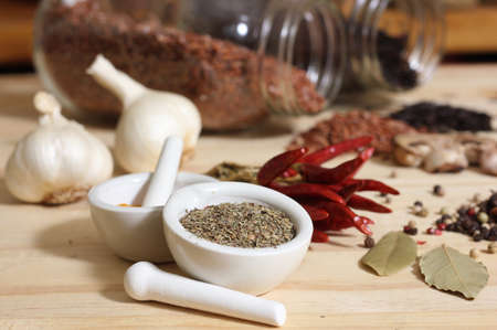 Herbs and Spices on Rustic Table With Jars of Red and Brown Rice in Background Shallow DOF