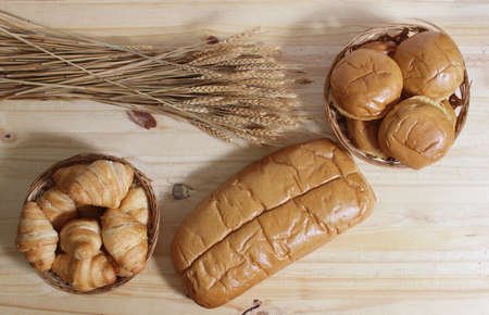 Fresh Baked Bread in Rustic Kitchen on Wooden Table With Wheat Stalks Top View