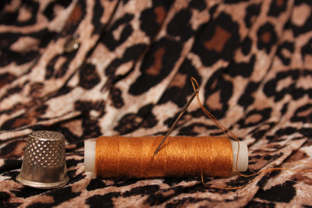 Spool of Tan Thread on Vintage Leopard Print Fabricの写真素材