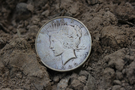 1922 Silver Peace Dollar On Ground in Dirt. Front Viewの写真素材