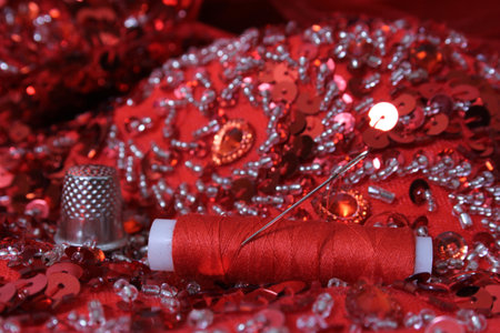 Red Beaded Fabric With Spool of Thread and Thimble