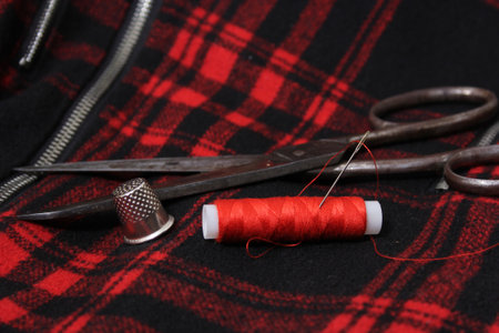 Red and Black Plaid Fabric With Thread and Scissors Close upの写真素材