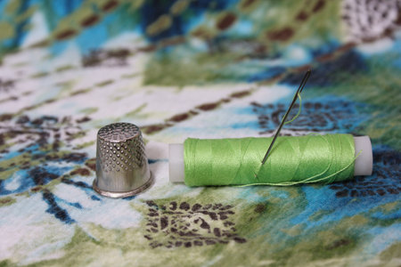 Green Thread With Thimble and Needle on Vintage Fabricの写真素材