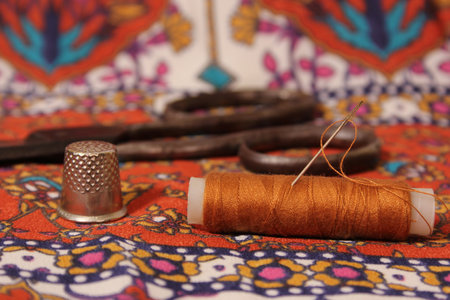 Thread With Thimble and Scissors on Vintage Fabric
