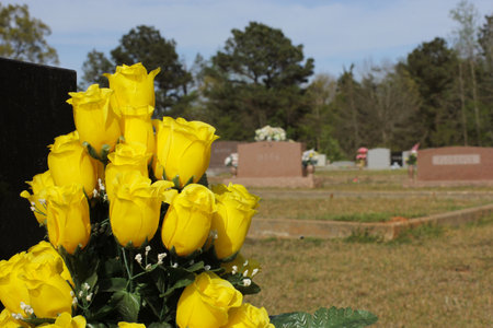 Artificial Yellow Rose Bouquet on Grave. Rural Cemetery. Shallow DOF