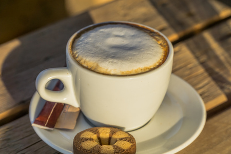 cappuccino coffee in a white cup. with cinnamone and biscuitsの写真素材