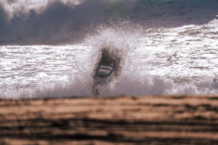 Jet ski towing a surfer jumping a wave.
