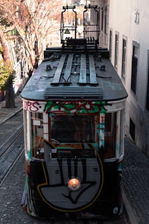 LISBON, PORTUGAL - February 1, 2022: famous GlÃ³ria funicular with a graffiti of a fist painted on the front.のeditorial素材