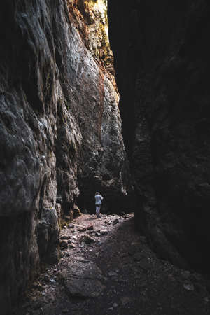 Girl in a very narrow dark rock canyon.の写真素材
