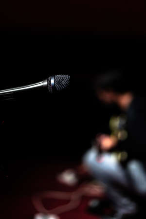 Close-up microphone with a person out of focus with a guitarの写真素材