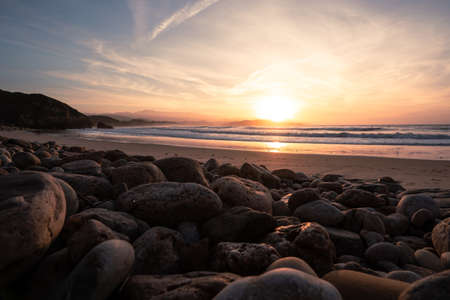 Rocky beach with round stones during sunsetの写真素材
