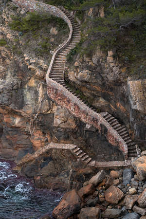 Ancient stone stairs leading down to the seaの写真素材
