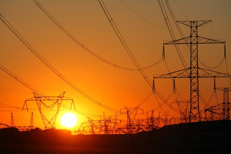 high voltage towers at orange sunset