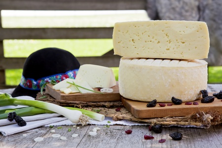 Big pieces of traditional white cheese on organic farm with fresh vegetables and dried fruits. の写真素材