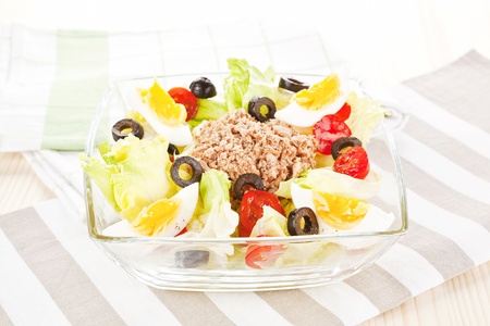 Delicious colorful tuna salad with tomatoes, olives and eggs. Fresh summer salad.の写真素材