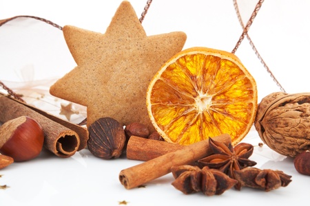 Traditional classic natural christmas decoration. Gingerbread, cinnamon, various nuts and orange. Brown festive xmas still life.の写真素材