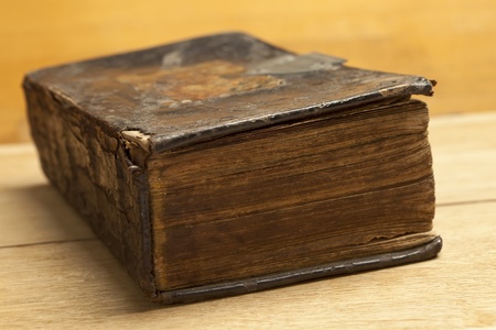 Antique aged book on wooden background. Vintage bible on leather hardcover.の写真素材