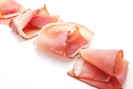 Prosciutto slices arranged isolated on white background. Culinary traditional meat.の写真素材
