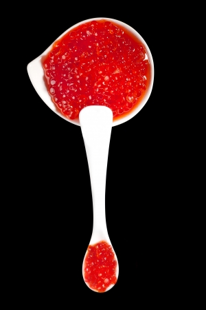 Luxurious caviar background  Caviar on white spoon and white bowl isolated on black background  Top view  Luxury food concept,の写真素材