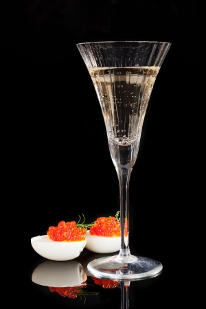 Caviar in egg with dill and champagne in glass isolated on black background. Luxury concept. の写真素材