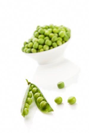 Pea pod and peas in bowl isolated on white background. Culinary summer legume vegetable. の写真素材