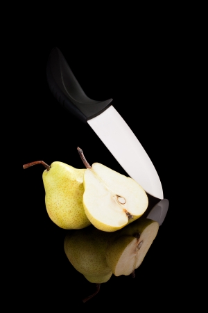 Pear with ceramic knife isolated on black background with reflection  Fruits in luxurious black の写真素材