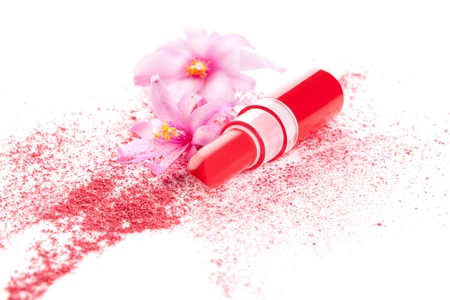 Red lipstick, spilled purple facial makeup powder and pink flowers isolated on white background  Feminine glamour makeup concept in red, purple and pink  の写真素材
