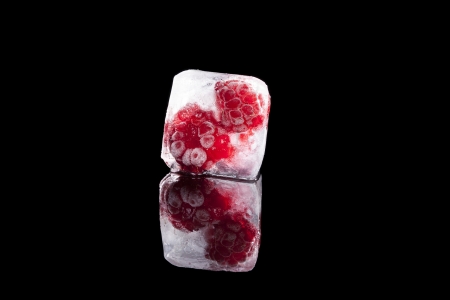 Fresh ripe raspberry frozen in ice cube. Fresh summer fruit concept.の写真素材