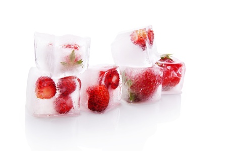 Delicious fresh strawberries frozen in ice cubes isolated on white background. Fresh summer fruits.の写真素材