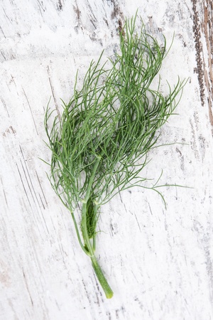 Culinary fresh dill on white wooden background, top view. Culinary aromatic kitchen herbs.の写真素材