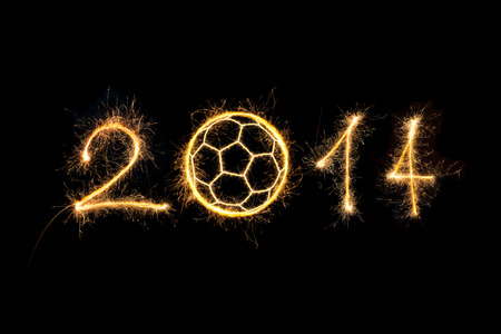 Soccer ball and the numbers 2014 made of sparkles isolated on black background.