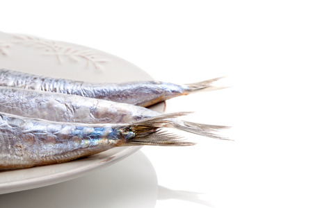 Luxurious seafood background. Fish tails on plate isolated on white background.の写真素材