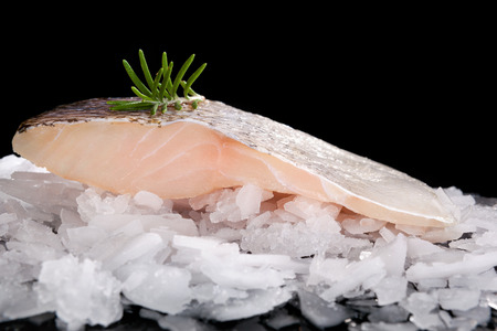 Fresh fish on crushed ice isolated on black background. Culinary fresh fish eating.の写真素材