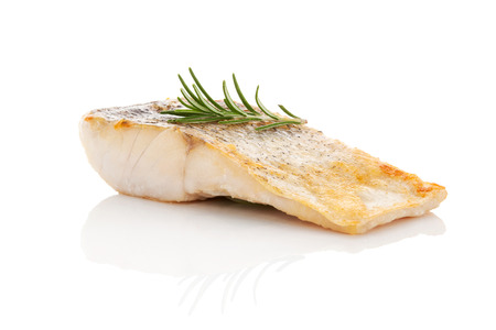 Luxurious seafood dinner. Perch fish fillet isolated on white background with fresh green herbs....