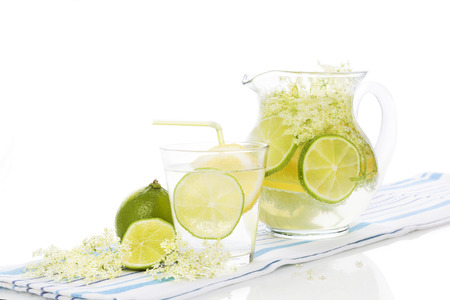 Elderberry lemonade with fresh lemon and lime and elderberry blossom isolated on white background. Fresh summer healthy drink.の写真素材
