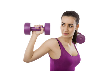 Beautiful girl with purple top and purple dumbbells isolated on white background. Sport and fitness, healthy living.の写真素材
