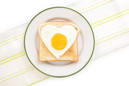 Fried egg sunnyside in heart shape on plate, top view. I love breakfast. Fresh modern image...