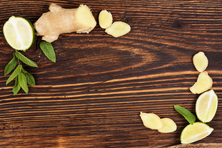 Healthy fruit eating. Ginger and lime on wooden table, top view with copyspace. Healthy fresh fruit eating.の写真素材