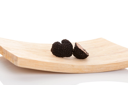 Cut truffles on wooden plate isolated on white backgroundの写真素材