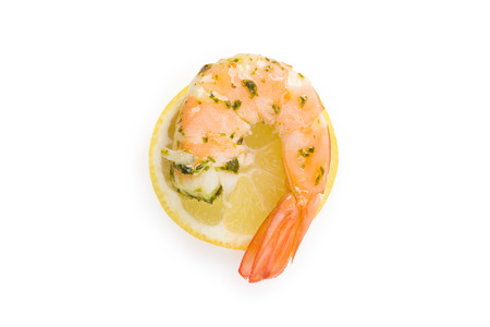 Cooked shrimp on lemon slice on white background top view. Culinary seafood eating.の写真素材